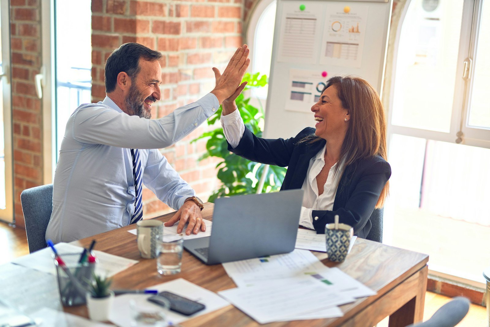 Two professionals shaking hands across a table